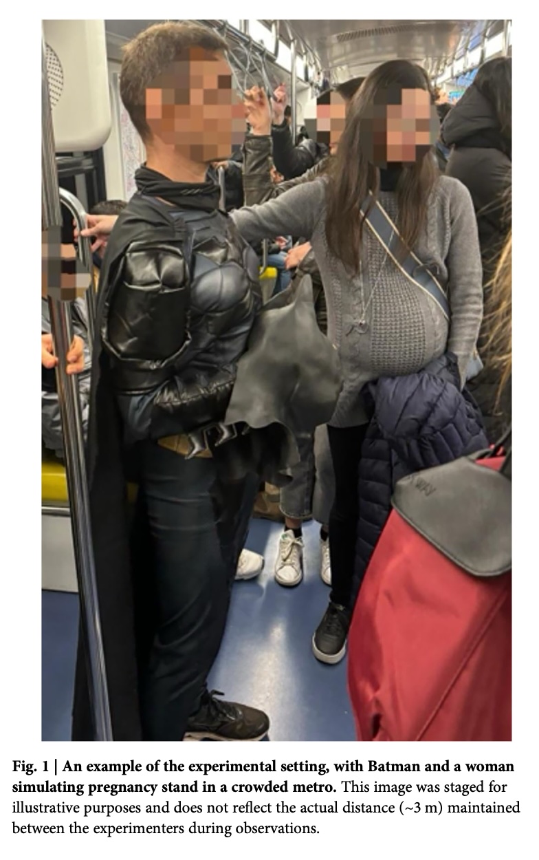 Batman and a woman in a crowded metro
